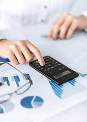 Image showing woman hand with calculator and papers