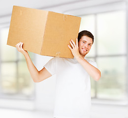 Image showing smiling man carrying carton box