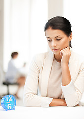 Image showing businesswoman looking at alarm clock