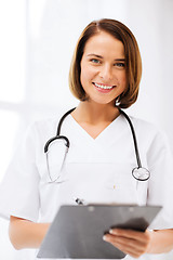 Image showing doctor with stethoscope writing prescription