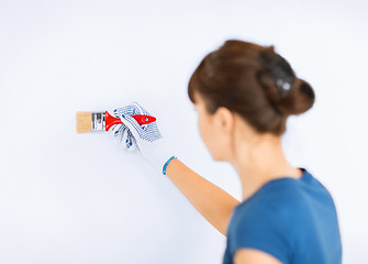 Image showing woman with paintbrush colouring the wall