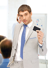 Image showing businessman showing credit card in office