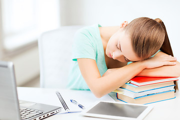 Image showing tired student sleeping on stock of books