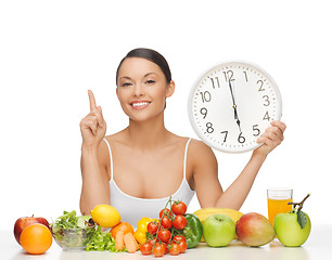 Image showing woman with fruits, vegetables and clock