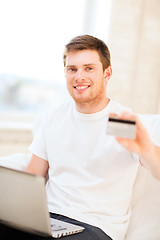 Image showing man with laptop and credit card at home