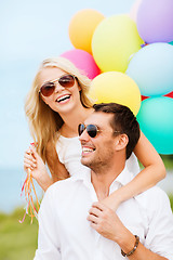 Image showing couple with colorful balloons at seaside