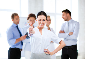 Image showing businesswoman in office showing thumbs up