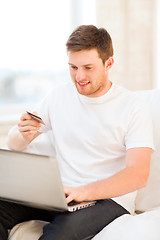 Image showing man with laptop and credit card at home