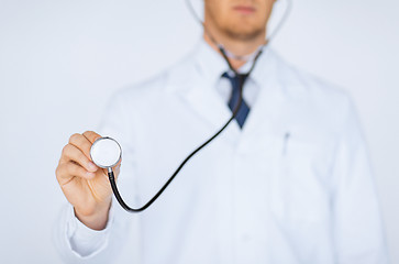 Image showing doctor hand with stethoscope listening something