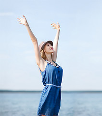 Image showing girl with hands up on the beach