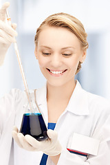 Image showing female chemist holding bulb with chemicals