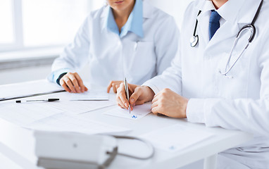 Image showing doctor and nurse writing prescription paper