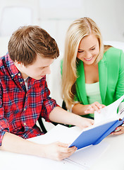 Image showing smiling students reading book at school