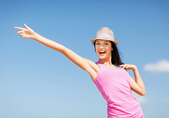 Image showing girl in hat showing direction on the beach