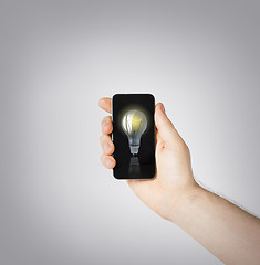 Image showing man hand holding smartphone with light bulb