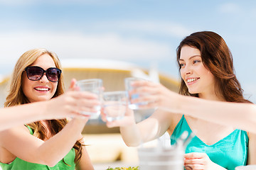 Image showing girls making a toast in cafe on the beach