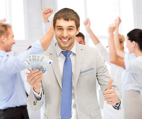 Image showing happy businessman with cash money in office