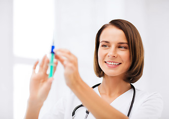 Image showing female doctor holding syringe with injection