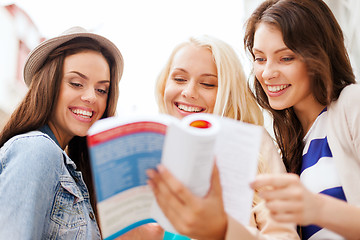 Image showing beautiful girls looking into tourist book in city