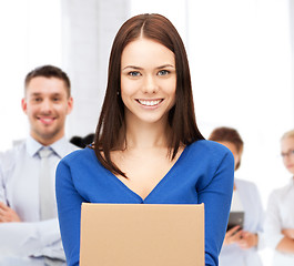 Image showing smiling woman holding cardboard box