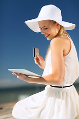 Image showing woman in hat doing online shopping outdoors