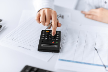 Image showing woman hand with calculator and papers