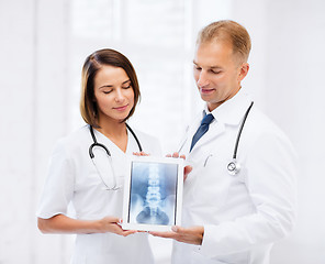 Image showing two doctors showing x-ray on tablet pc