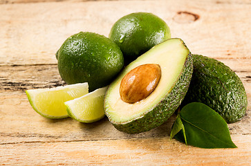 Image showing avocado and limes on wooden background