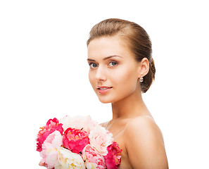 Image showing woman wearing earrings and holding flowers