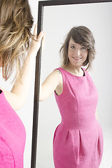 Image showing real young woman looking in a mirror
