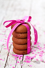 Image showing chocolate cookies tied with pink ribbon and confetti 