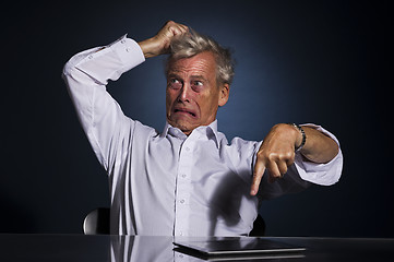 Image showing Upset frustrated senior man pointing at his tablet