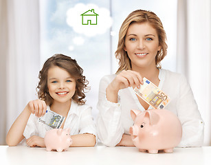 Image showing mother and daughter saving money