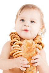 Image showing cute todler eating long bread