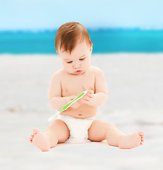 Image showing little baby playing with toothbrush