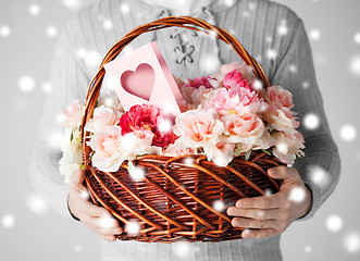 Image showing man holding basket full of flowers and postcard