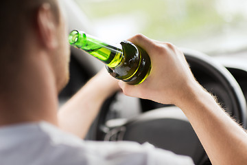 Image showing man drinking alcohol while driving the car