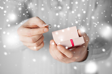 Image showing man holding wedding ring and gift box