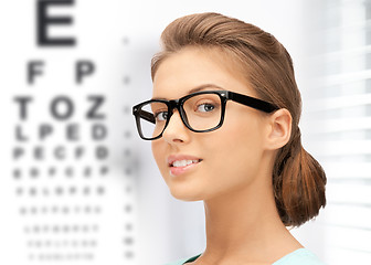 Image showing woman in eyeglasses with eye chart