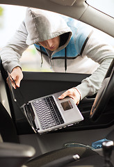 Image showing thief stealing laptop from the car