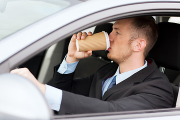 Image showing man drinking coffee while driving the car