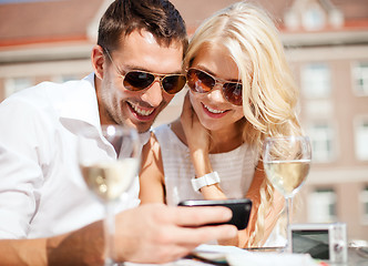Image showing couple looking at smartphone in cafe