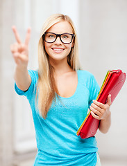 Image showing smiling student with folders showing victory sign