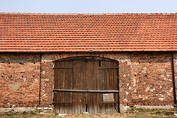 Image showing Old brick barn with wooden gate