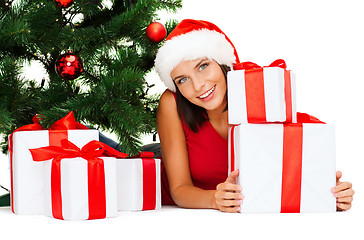 Image showing smiling woman in santa helper hat with gift boxes