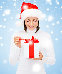 Image showing smiling woman in santa helper hat with gift box