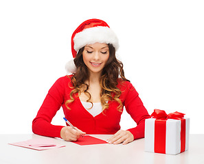 Image showing smiling woman in santa helper hat with postcard