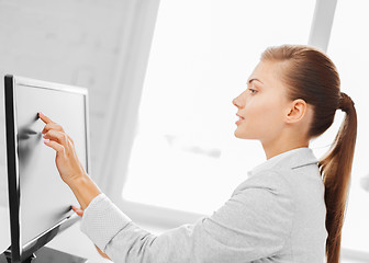 Image showing smiling businesswoman with touchscreen in office