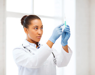 Image showing african doctor holding syringe with injection