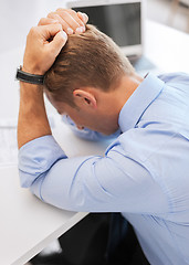 Image showing stressed businessman with papers at work